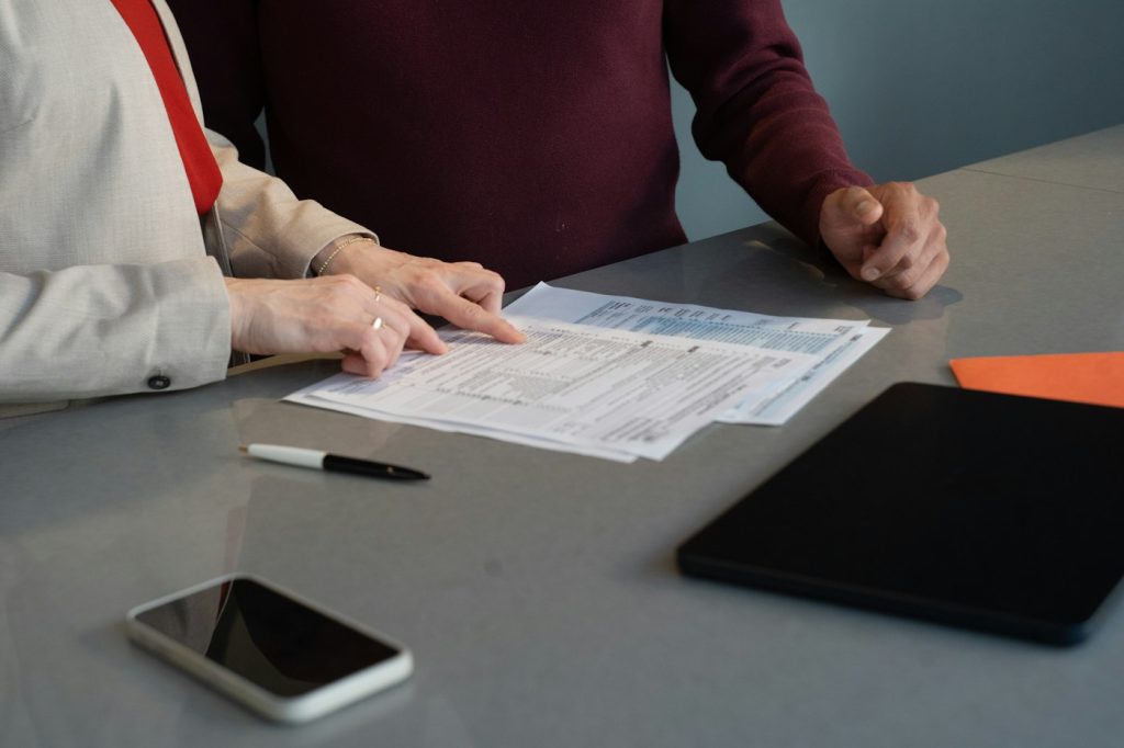 Couple relisant à la maison une offre de prêt et une notice d'assurance emprunteur